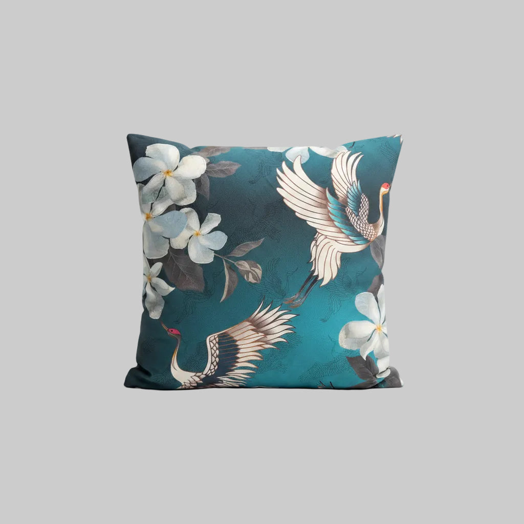 Decorative cushion with Japanese cranes blossoms on a teal backing